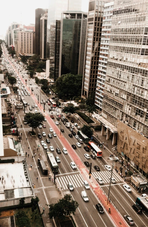 a city street filled with lots of traffic next to tall buildings, inspired by Thomas Struth, trending on unsplash, sao paulo, low quality photo, 8k 28mm cinematic photo, high view