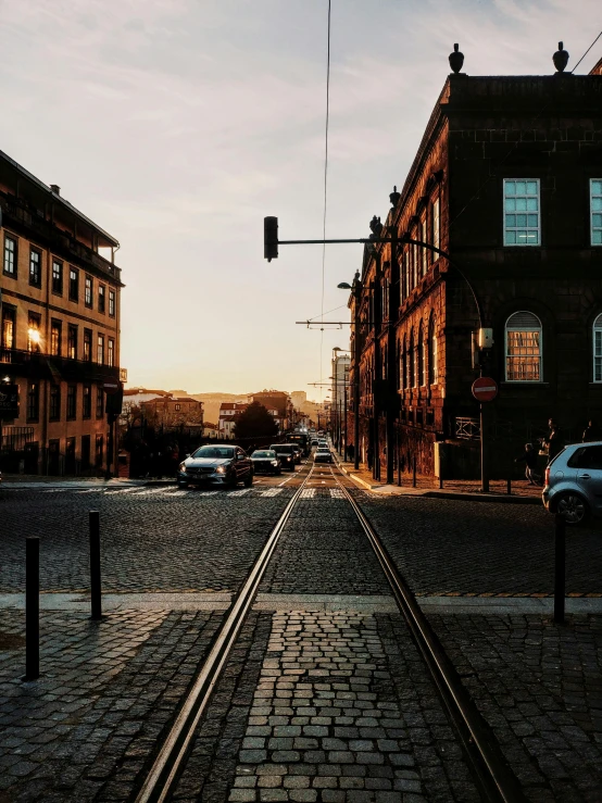 a train track in the middle of a city street, a picture, pexels contest winner, summer evening, in a city with a rich history, seen from outside, back facing the camera