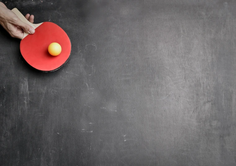 a person holding a ping pong paddle over a table, pexels contest winner, bauhaus, chalkboard, background image, red yellow, an egg