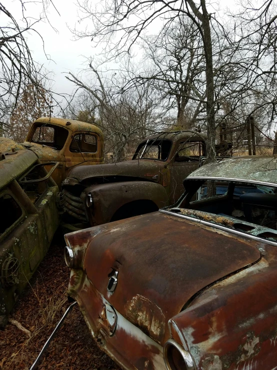 a bunch of old cars that are sitting in the dirt, photograph, ((rust))