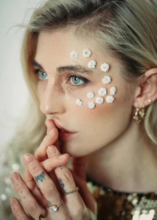 a woman with white paint on her face, an album cover, inspired by Elsa Bleda, trending on pexels, aestheticism, floral bling, katherine mcnamara inspired, delicate embellishments, pixel perfect