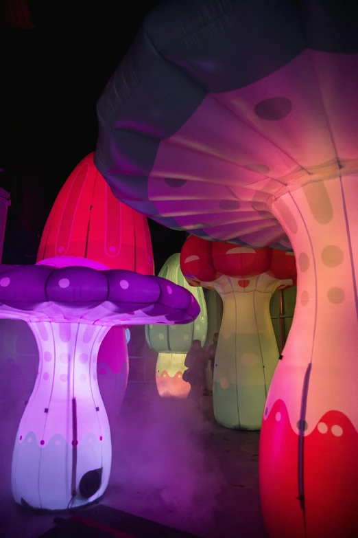 a group of illuminated mushrooms sitting next to each other, an abstract sculpture, interactive art, inflatable, fairy palace, purple, from alice in wonderland