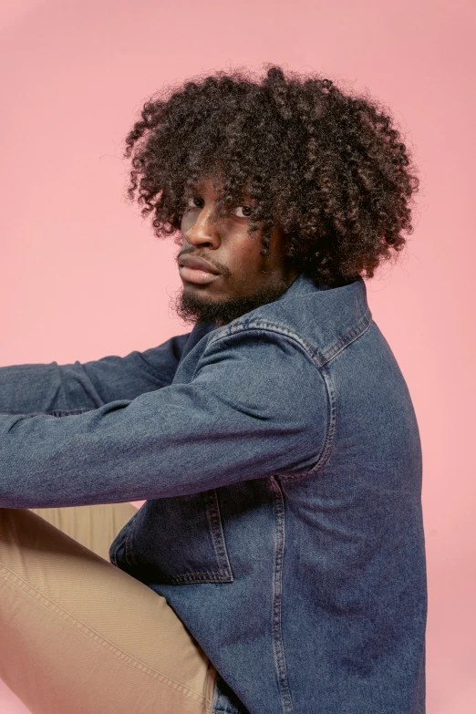 a man wearing a denim jacket and khaki pants, an album cover, inspired by Charles Martin, trending on pexels, natural hair, photo of a model, the thinker, big hair