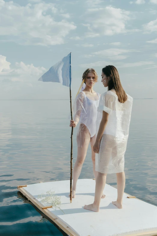 a couple of women standing on top of a boat, inspired by Enrique Simonet, unsplash contest winner, conceptual art, holding a white flag, see - through, runway photo, pale blue