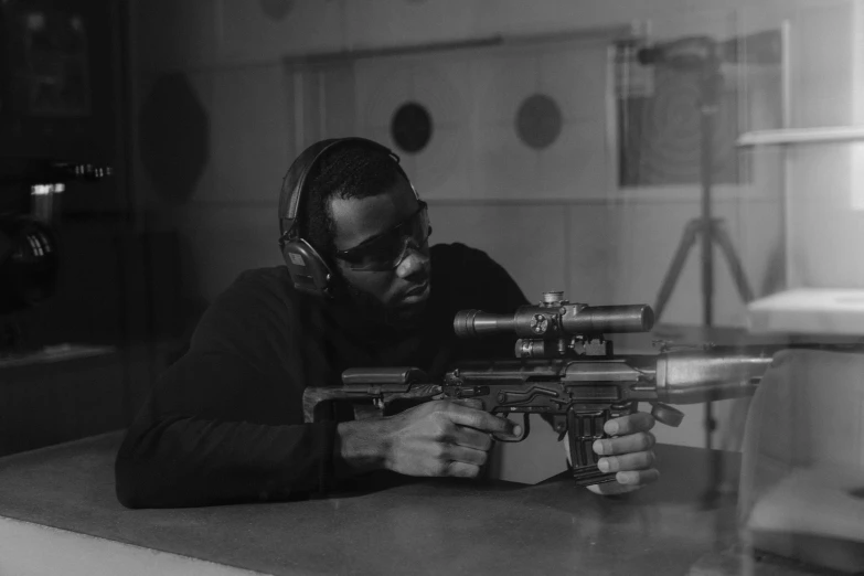 a man sitting at a table with a machine gun, by Sam Charles, pexels contest winner, ebony, holding a laser gun, profile picture 1024px, very grainy image