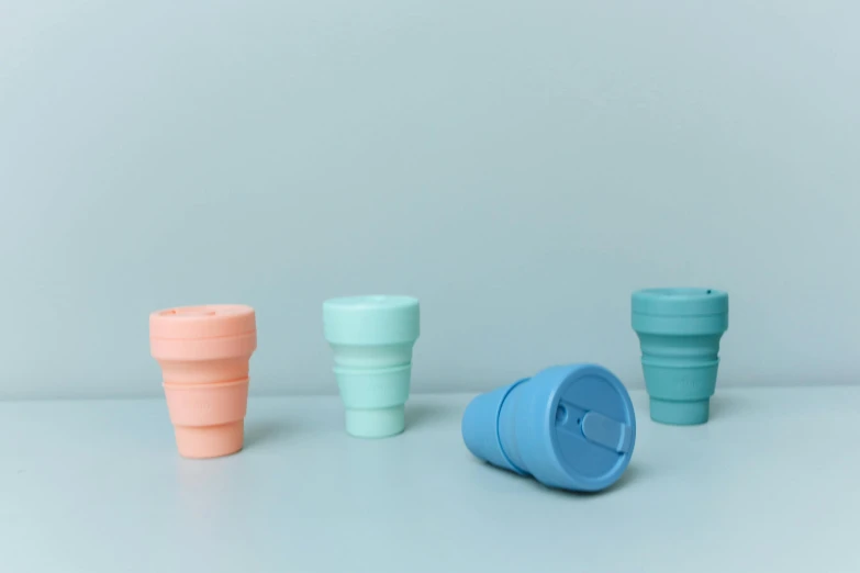 a couple of cups sitting on top of a table, product image, soft cool colors, silicone skin, megabuildings