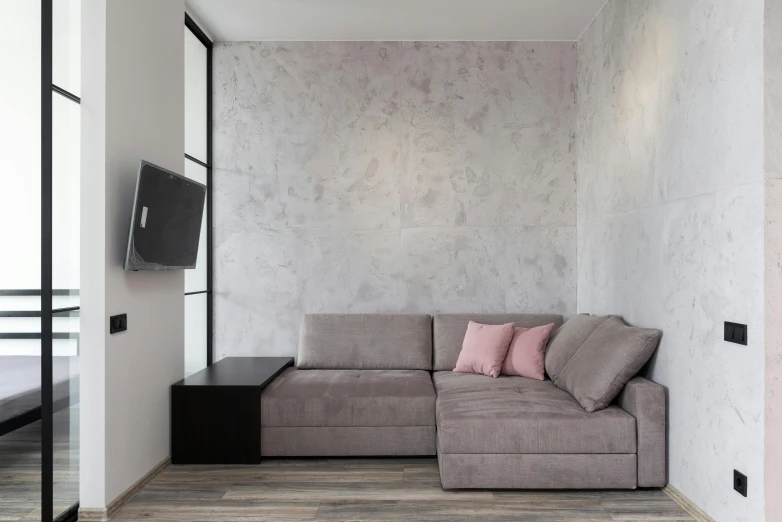 a living room with a couch and a flat screen tv, inspired by Emilio Grau Sala, unsplash contest winner, minimalism, pink and grey muted colors, small bedroom, gray concrete, pristine quality wallpaper