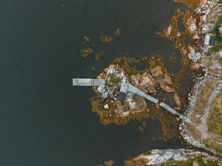 an aerial view of a bridge over a body of water, by Jesper Knudsen, pexels contest winner, hurufiyya, rocky shore, small dock, thumbnail, grey