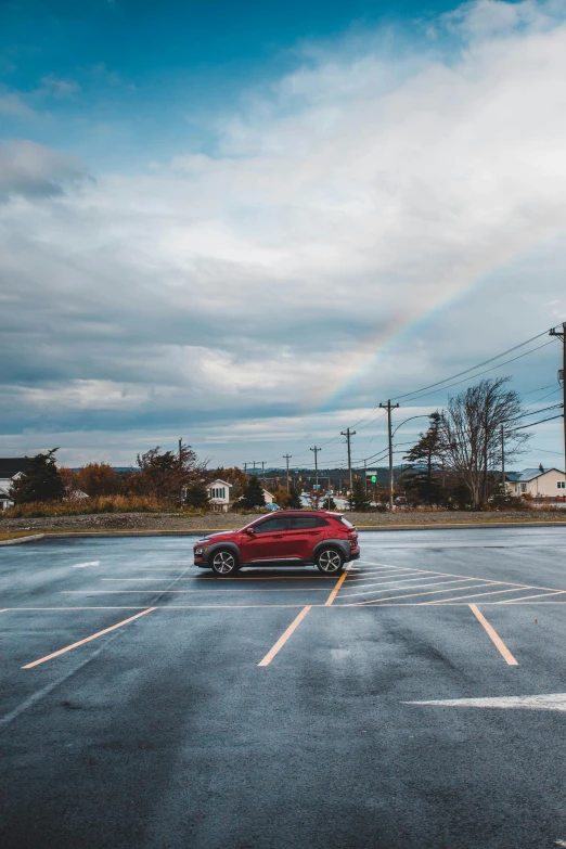 a red car is parked in a parking lot, by Daniel Seghers, unsplash contest winner, grey skies with two rainbows, quebec, square, 2019 trending photo