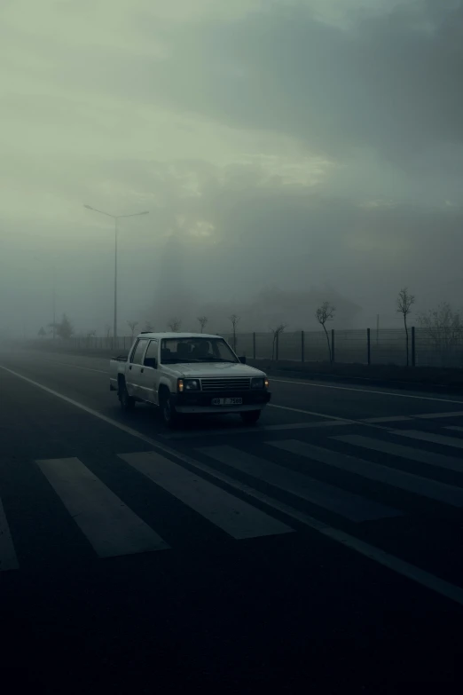 a car driving down a road on a foggy day, an album cover, inspired by Elsa Bleda, romanticism, azamat khairov, ((mist)), square, aykut aydogdu