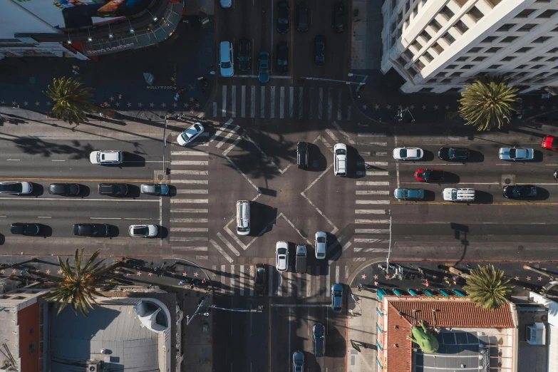 a street filled with lots of traffic next to tall buildings, by Adam Marczyński, pexels contest winner, birds - eye view, square, los angelos, crosswalk