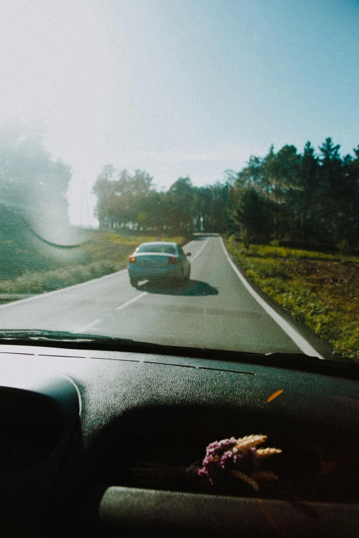 a car driving down the road on a foggy day, by Jacob Toorenvliet, happening, sunny day time, gopro footage, rectangle, cinematic shot ar 9:16 -n 6 -g