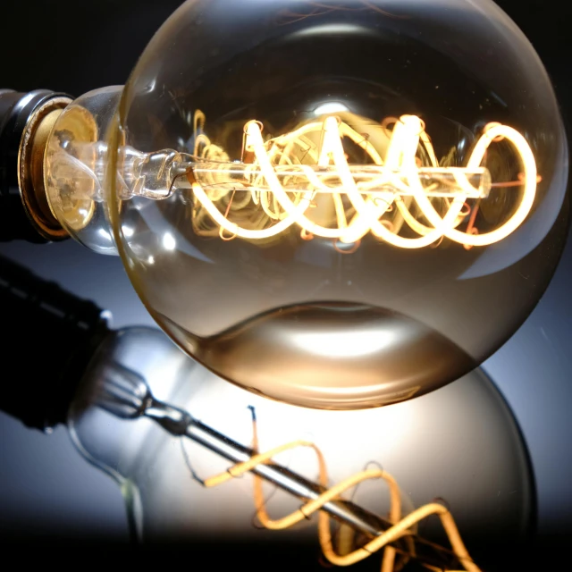 a close up of a light bulb on a table, inspired by George Fiddes Watt, electric swirls, twisted wire, 1920s studio lighting, led lamps