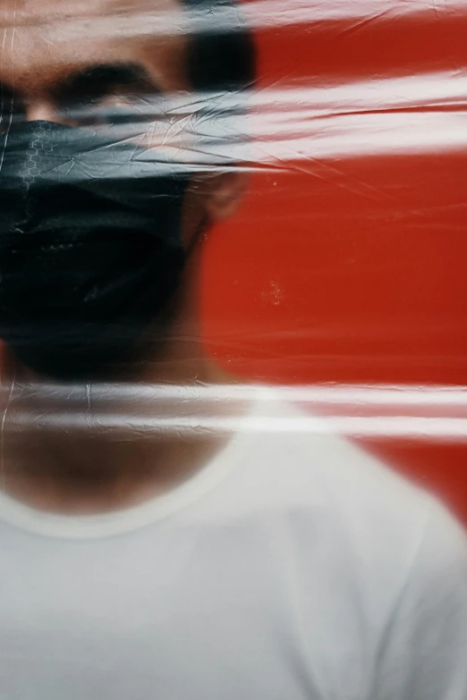 a man with a black mask covering his face, a picture, pexels contest winner, lyrical abstraction, red and white colors, in plastic, 256435456k film, looking across the shoulder