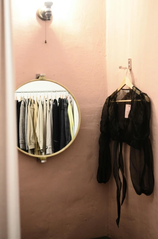 a mirror that is on a wall in a room, by Nicolette Macnamara, trending on unsplash, with clothes on, store, ✨🕌🌙, pastel clothing