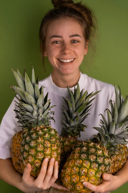 a woman holding two pineapples in her hands, by Matthias Stom, process art, greta thunberg smiling, scientific photo, close up portrait photo, portrait photo of a backdrop