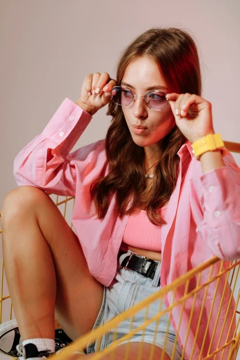 a woman is sitting in a shopping cart, inspired by Anita Malfatti, trending on pexels, pop art, pink glasses, cropped shirt with jacket, portrait sophie mudd, with a cool pose