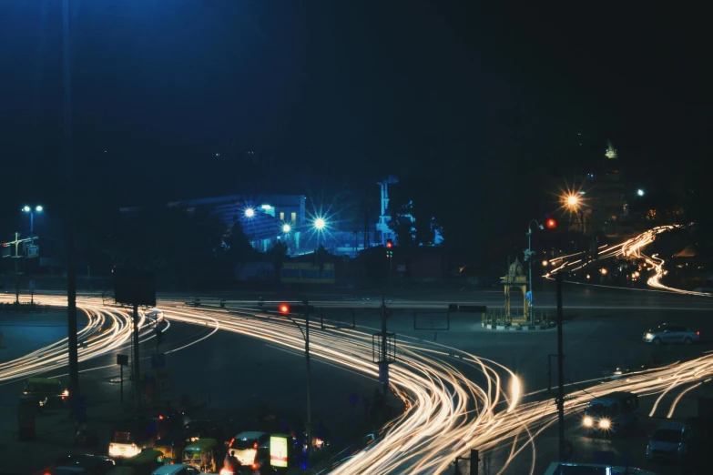 a city street filled with lots of traffic at night, unsplash contest winner, realism, bangalore, blue, twisting streets, low quality photo