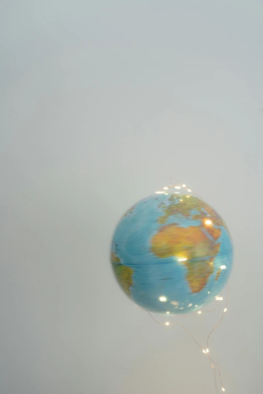 a person flying a kite that has a globe on it, inspired by Leandro Erlich, light and space, in the astral plane ) ) ), large globe, world map, taken in the late 2010s