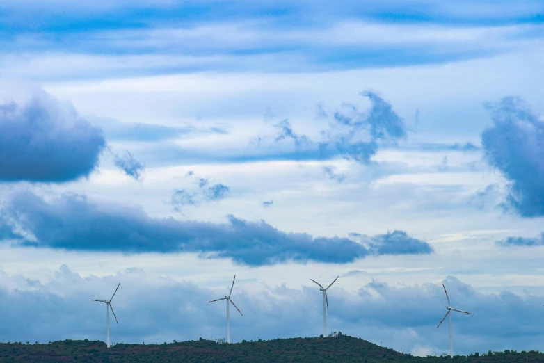 a group of wind turbines sitting on top of a lush green hillside, by Jesper Knudsen, pexels contest winner, dramatic clouds cyan atmosphere, panorama, 15081959 21121991 01012000 4k, plain background