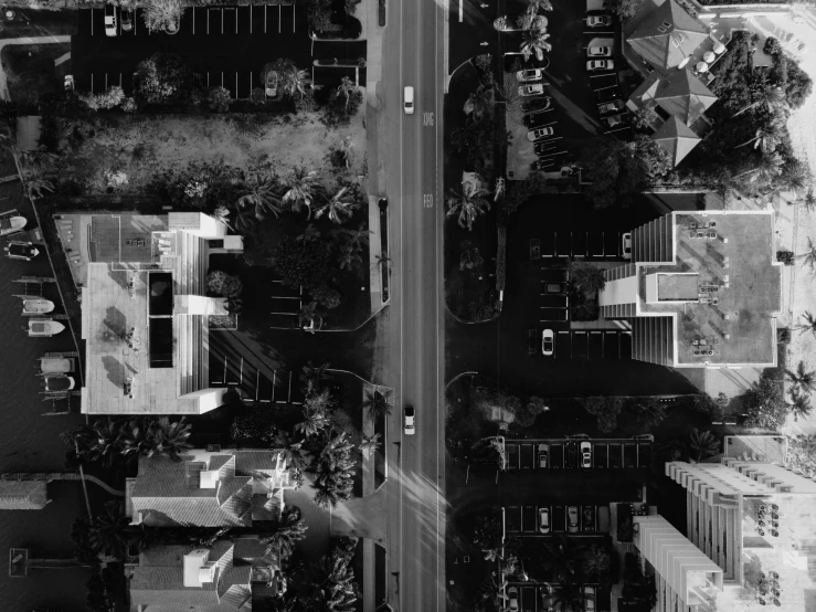 a black and white photo of a city street, a black and white photo, by Adam Rex, digital art, aerial footage, outdoors tropical cityscape, car, 4k footage