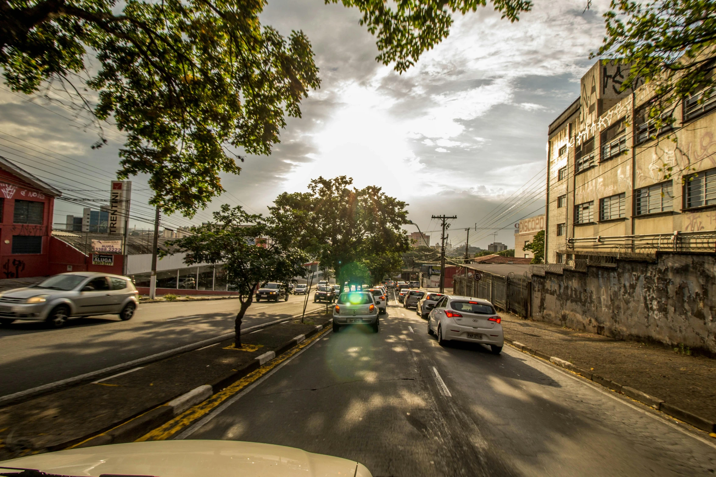 a street filled with lots of traffic next to tall buildings, by Felipe Seade, city of armenia quindio, golden hour cinematic, gopro photo, puerto rico