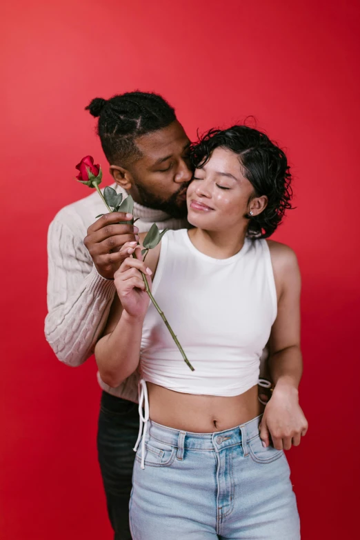 a man standing next to a woman holding a rose, by Cosmo Alexander, trending on pexels, renaissance, mixed-race woman, lesbian kiss, solid background, 👅 👅