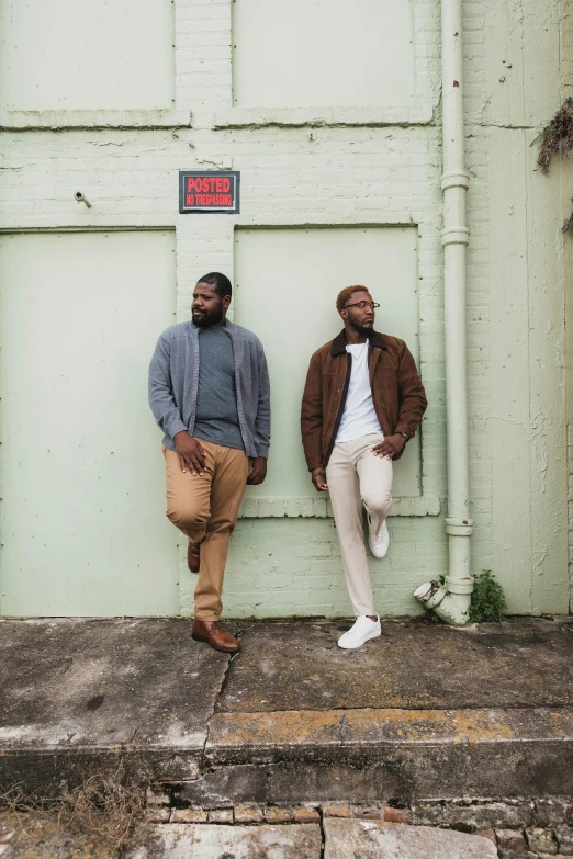 a couple of men standing next to each other, a portrait, by Richmond Barthé, unsplash, green and brown clothes, wide full body, r&b, gray canvas