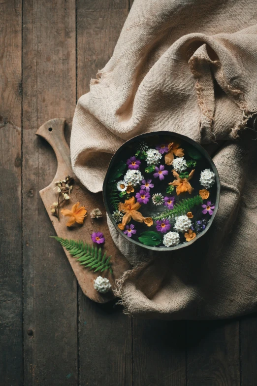 a bowl filled with flowers sitting on top of a wooden table, inspired by Elsa Bleda, trending on unsplash, renaissance, made of food, high quality photo, made of flowers and leaves, gourmet cooking