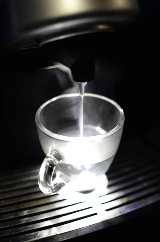 a close up of a cup of coffee on a table, at night, gelatine silver process, water-cooled, mechanised