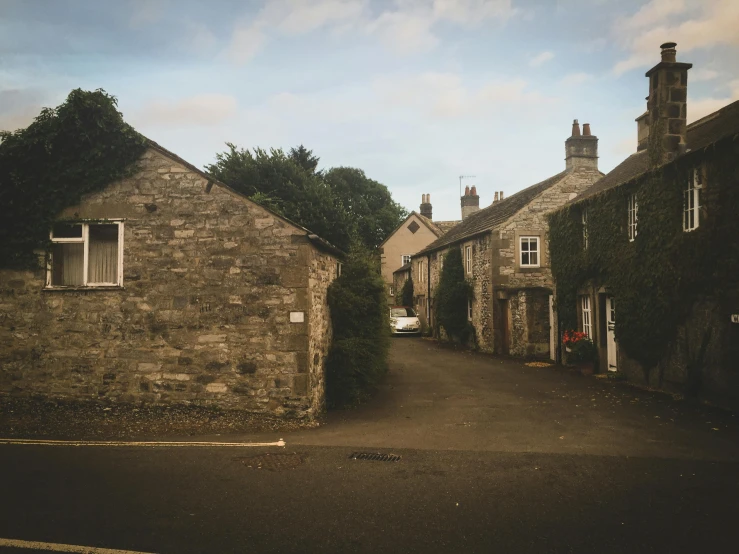 a couple of buildings that are next to each other, by Kev Walker, pexels contest winner, in a village street, shap, low quality photo, background image