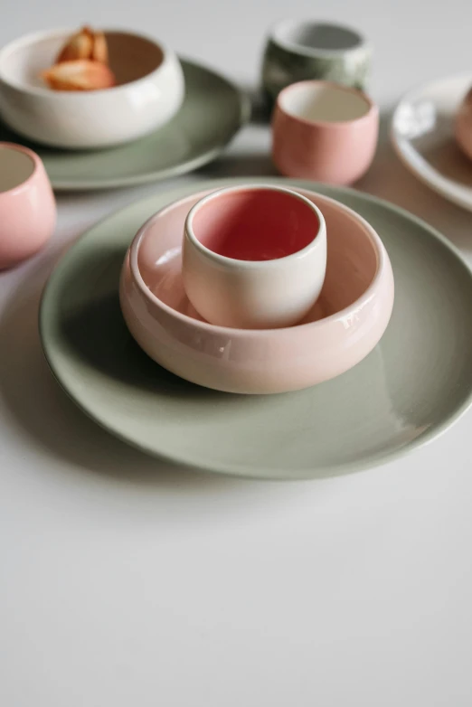 a table topped with plates and bowls of food, inspired by Giorgio Morandi, trending on unsplash, dau-al-set, green and pink, made of glazed, close-up product photo, round form