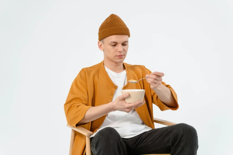 a man sitting in a chair eating from a bowl, trending on pexels, realism, brown jacket with long sleeves, avatar image, ramen, anato finnstark and kelogsloops