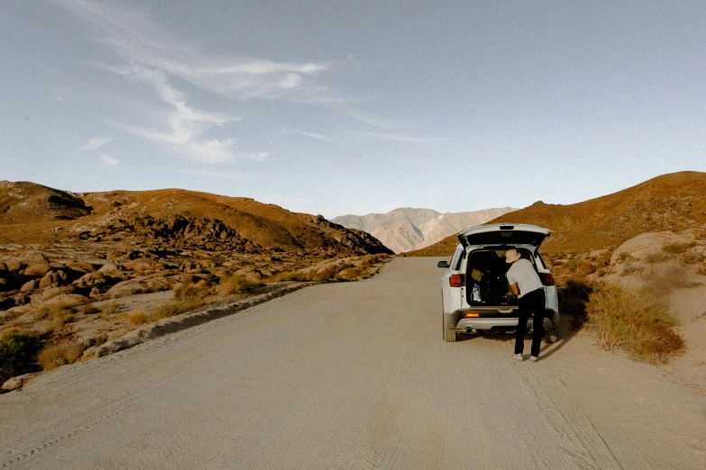 a white van parked on the side of a dirt road, by Julia Pishtar, palm springs, person in foreground, lachlan bailey, panoramic shot
