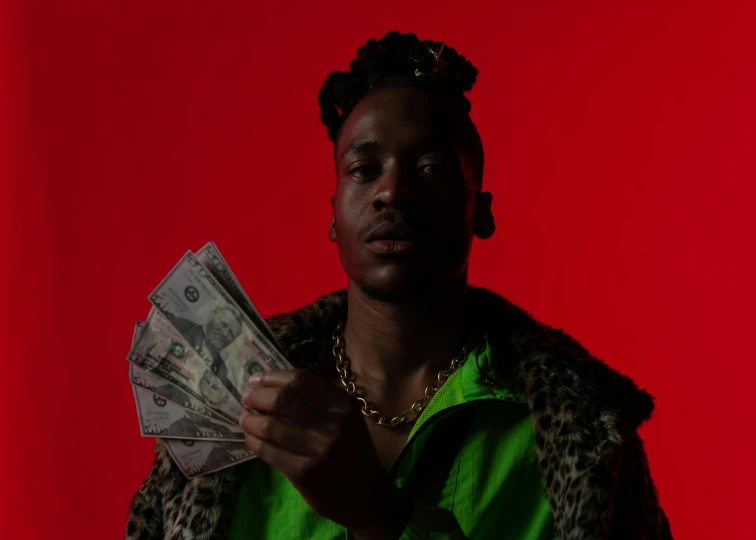 a man holding a bunch of money in his hand, an album cover, pexels contest winner, red skin, in style of tyler mitchell, glowing, shot with sigma f/ 4.2