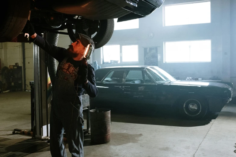 a man working on a car in a garage, by Jaakko Mattila, pexels contest winner, better call saul scene 1 0 8 0 p, seventies cinestill, burnout, getty images