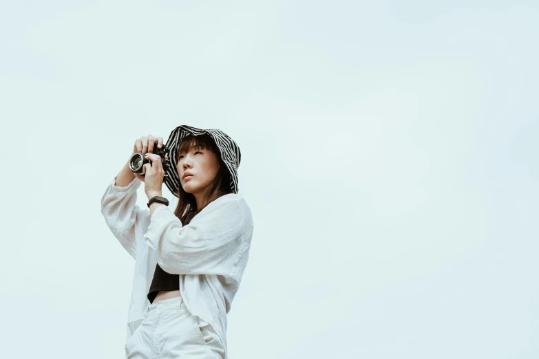 a woman holding a baseball bat on top of a field, unsplash contest winner, in front of white back drop, japanese woman, white hat, camera looking up