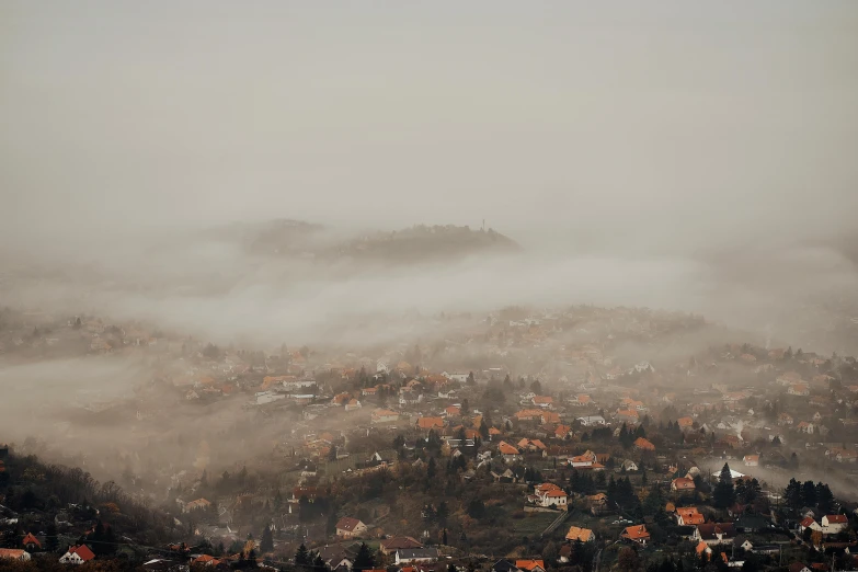 a view of a town on a foggy day, pexels contest winner, bosnian, in the bottom there a lot of fog, brown, filling the frame