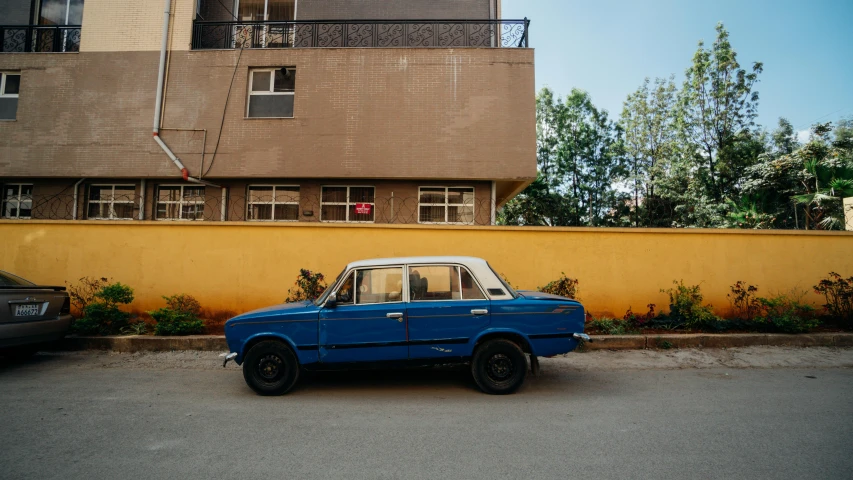 a blue car parked in front of a yellow building, by Sven Erixson, tehran, nostalgic 8k, soviet suburbs, with an intricate