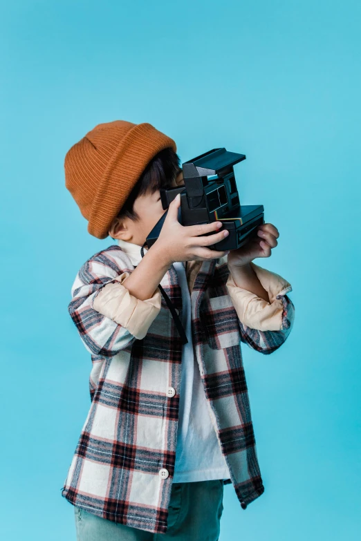 a little boy taking a picture with a camera, unsplash contest winner, visual art, with a blue background, hat covering eyes, toy commercial photo, hasselblad quality