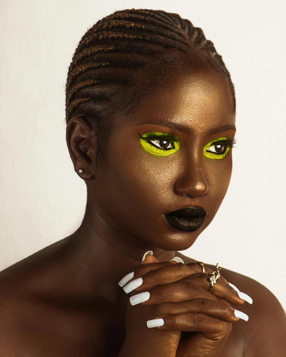 a close up of a person with green eyes, an album cover, trending on pexels, afrofuturism, yellow makeup, ( ( dark skin ) ), gradient from green to black, model posing