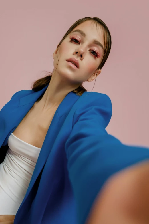 a woman in a blue jacket taking a selfie, by Gavin Hamilton, portrait sophie mudd, fashion editorial, pink and blue colour, doing an elegant pose over you