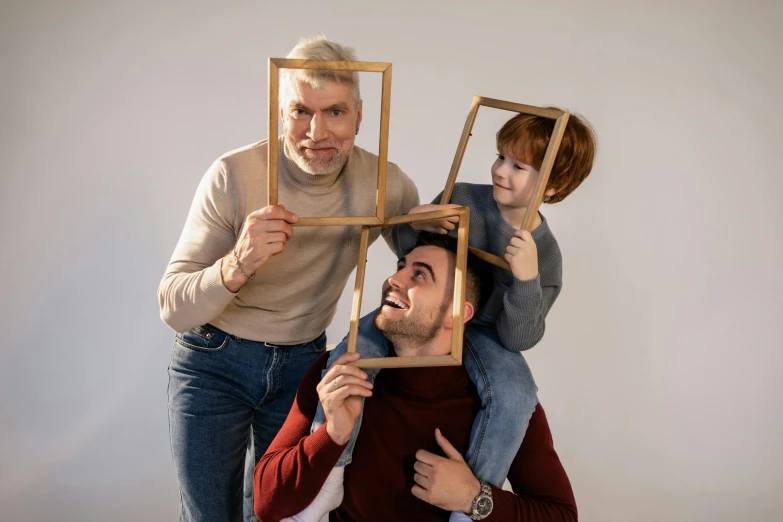 a man sitting on top of a woman holding a picture frame, pexels contest winner, conceptual art, three heads, with a kid, square shapes, old man