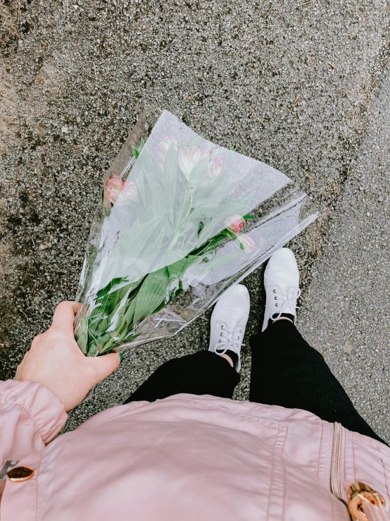 a person is holding a bunch of flowers, a picture, by Lucia Peka, trending on unsplash, white shoes, lonely and sad, ((pink)), paved