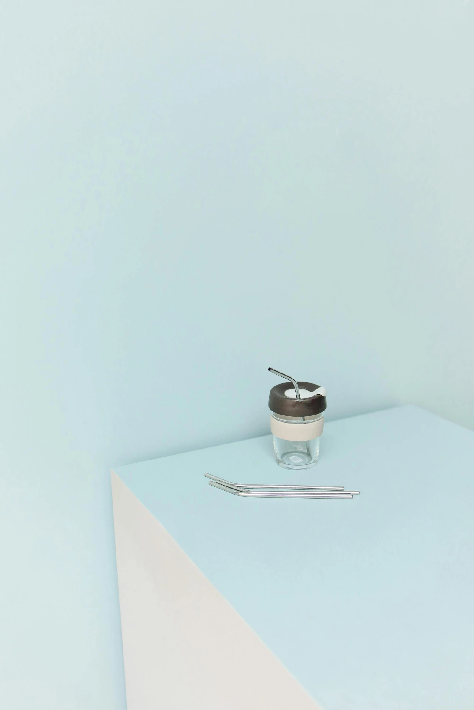 a cup of coffee sitting on top of a table, a still life, by Nina Hamnett, minimalism, stainless steel, yogurt, pastel blue, miniature product photo