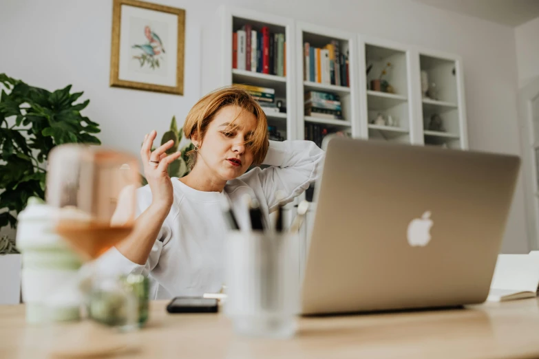 a woman sitting in front of a laptop computer, a photo, by Julia Pishtar, trending on pexels, exasperated, tinnitus, middle - age, avatar image