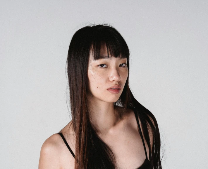 a woman with long black hair posing for a picture, pexels contest winner, shin hanga, with a fringe, set against a white background, kailee mandel, thin face structure