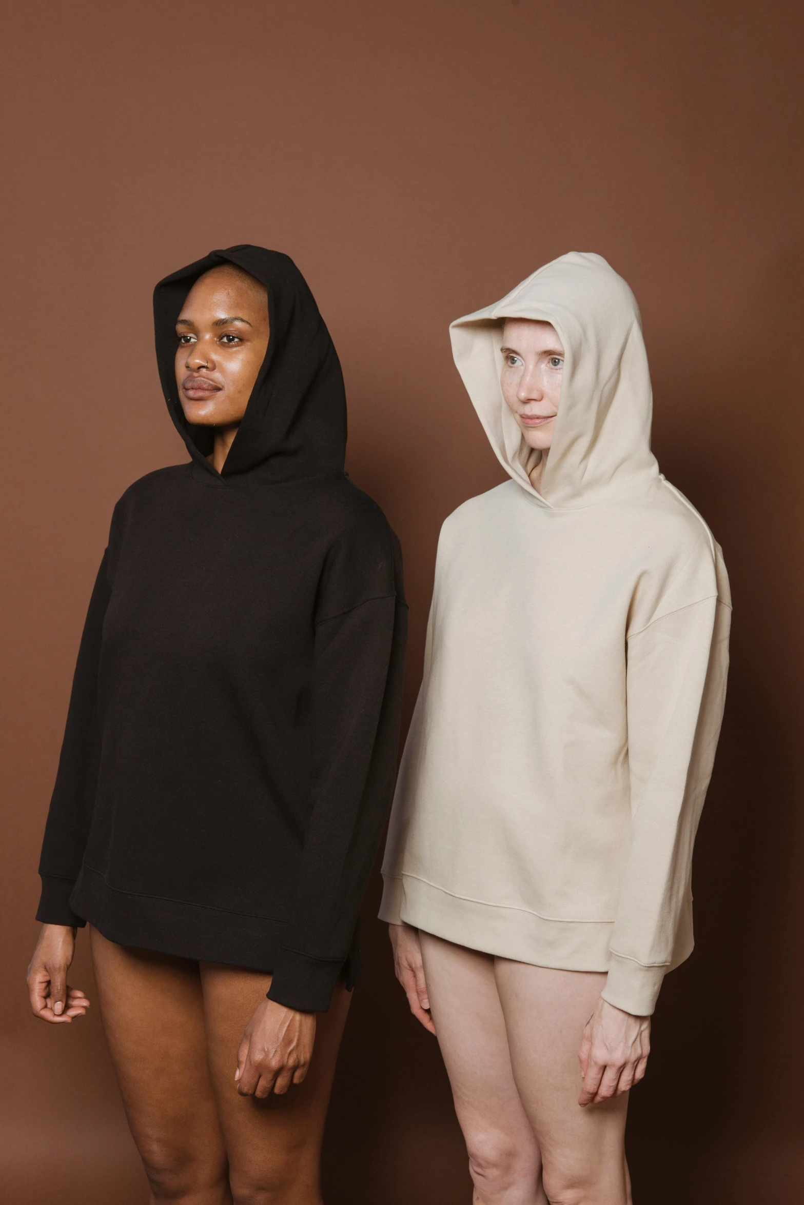 two women in hoodies standing next to each other, by Matija Jama, beige hoodie, or black, thumbnail, engineered