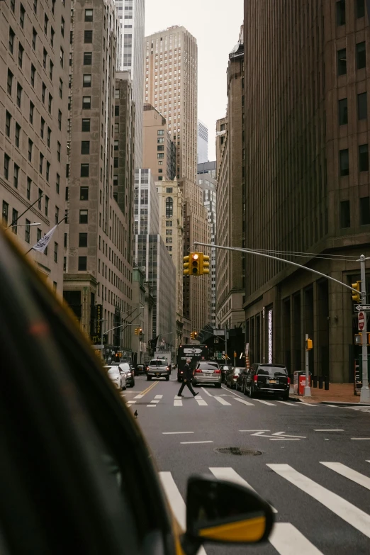 a city street filled with lots of tall buildings, a picture, pexels contest winner, inside of a car, ny, low quality photo