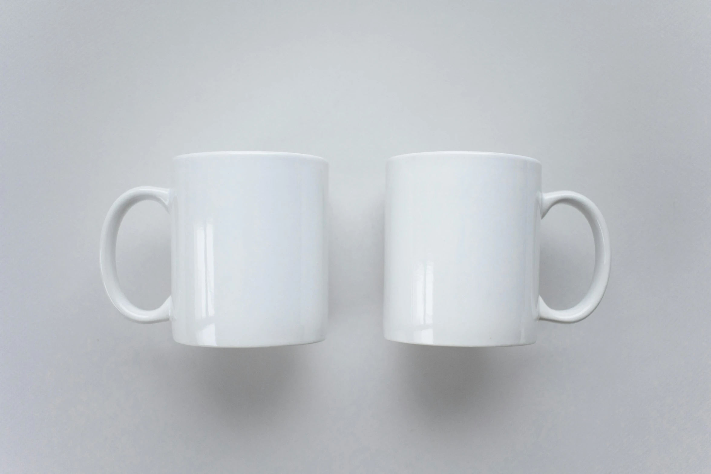 two white coffee mugs sitting next to each other, by Niels Lergaard, pexels, hyperrealism, symmetrical front view, white space, ultrarealistic, ( ultra realistic